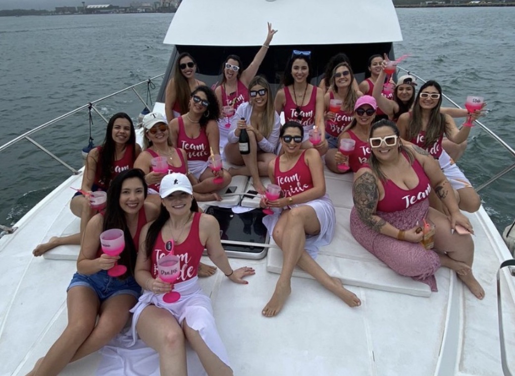 Grupo Team Bride de rosa na proa da lancha