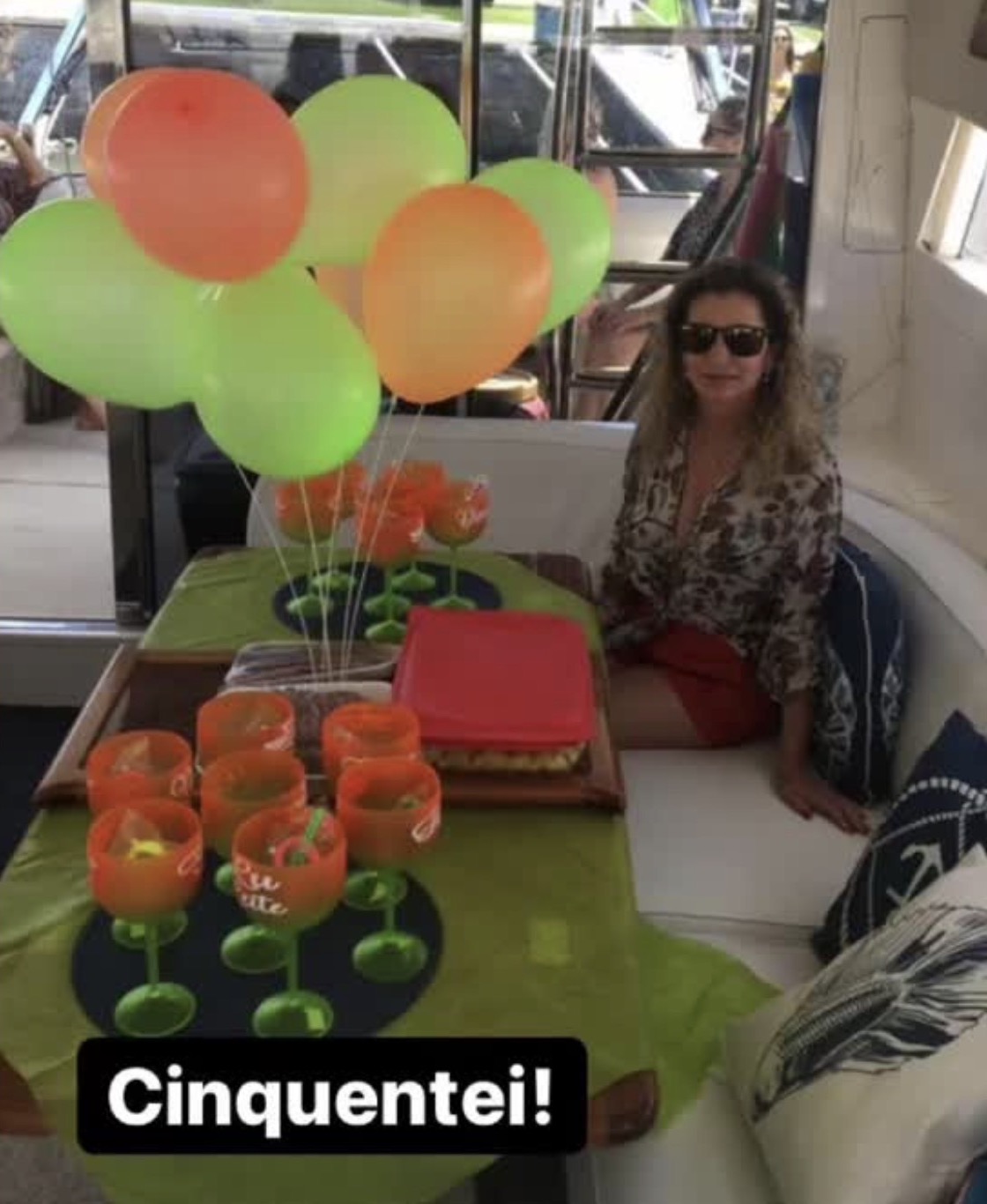 Aniversariante comemorando 50 anos na cabine da lancha decorada